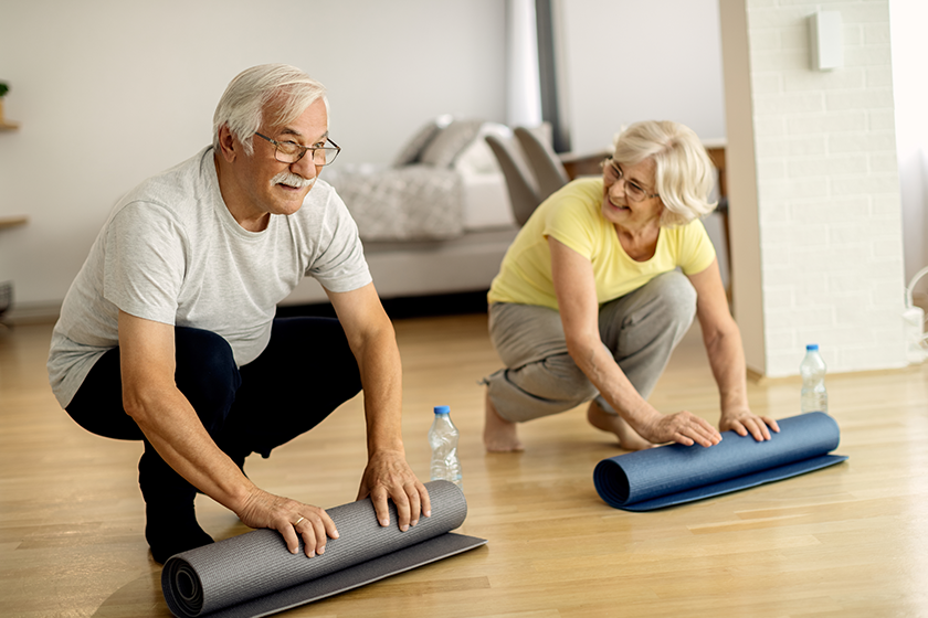 happy-senior-couple-rolling-exercise-mats